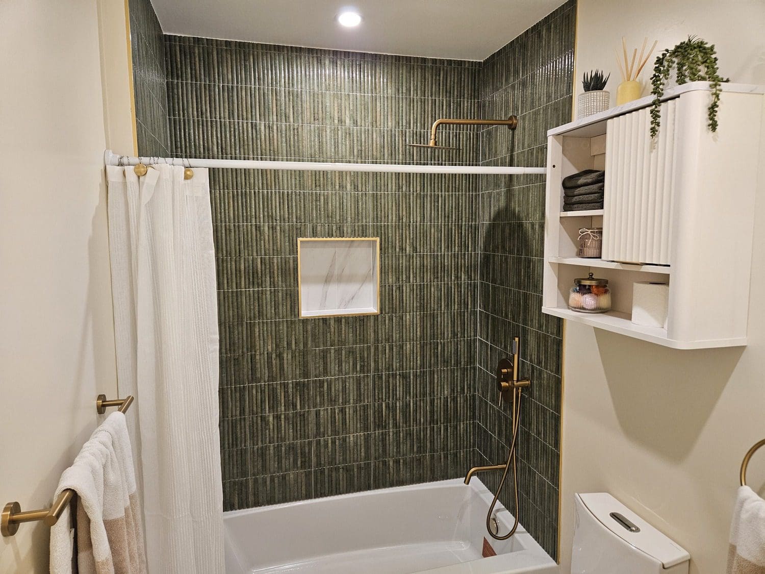 A bathroom with a tub, shower and toilet.