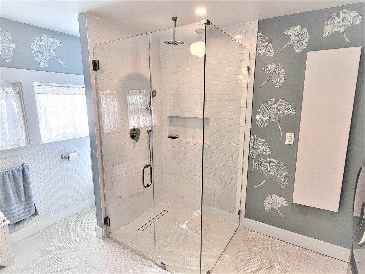 A bathroom with a large glass shower door.