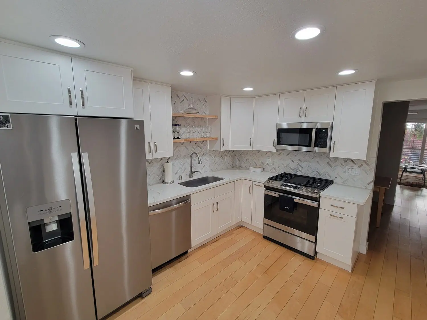 A kitchen with white cabinets and stainless steel appliances.