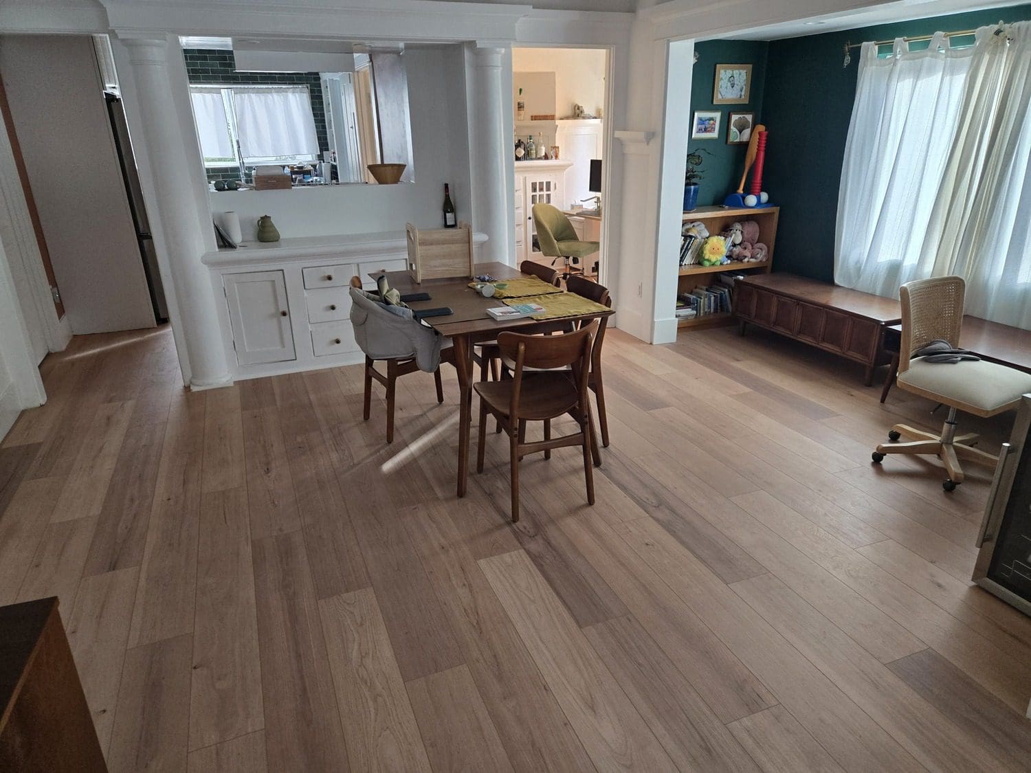 A dining room with wooden floors and chairs.