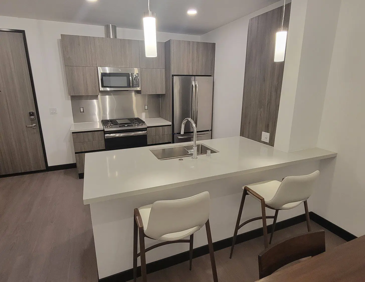 A kitchen with a sink, microwave and refrigerator.