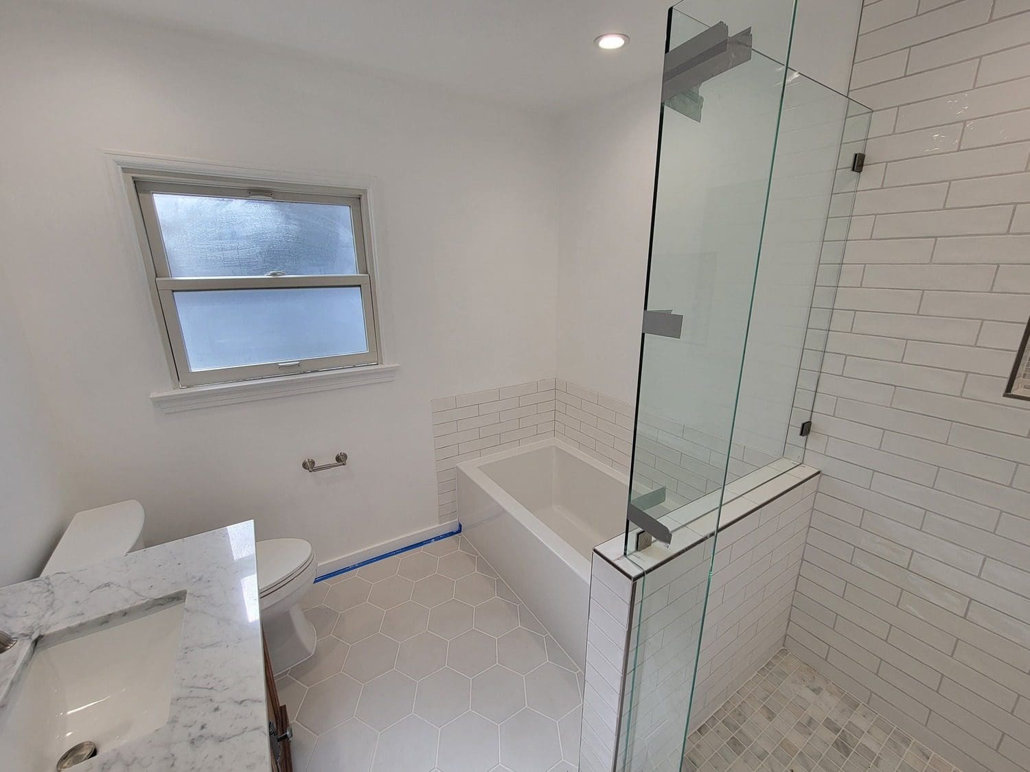 A bathroom with a tub, toilet and shower.