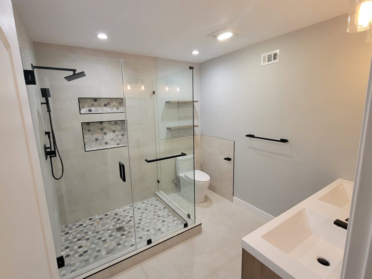 A bathroom with a shower, toilet and sink.