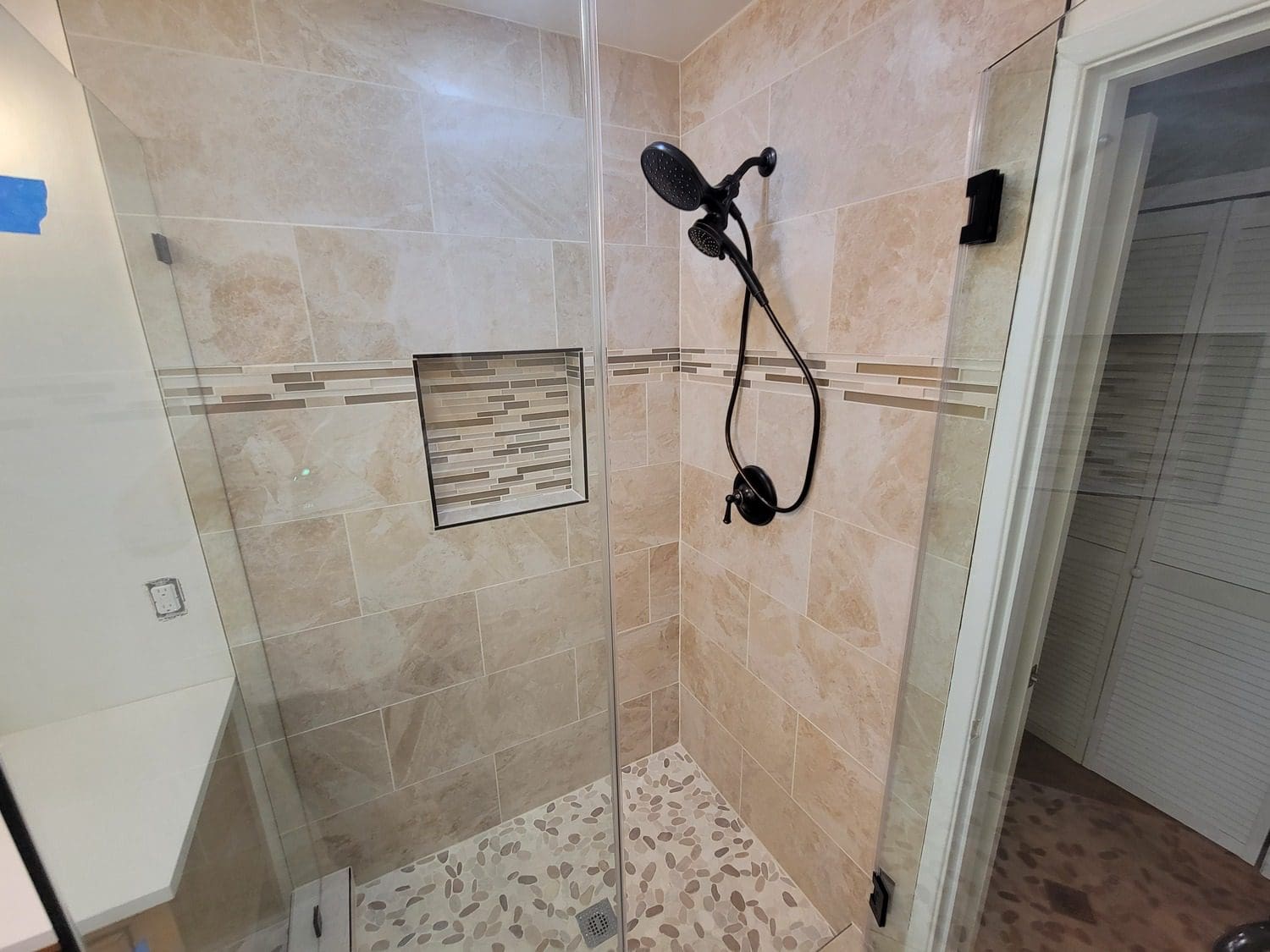 A bathroom with a shower and tiled walls.