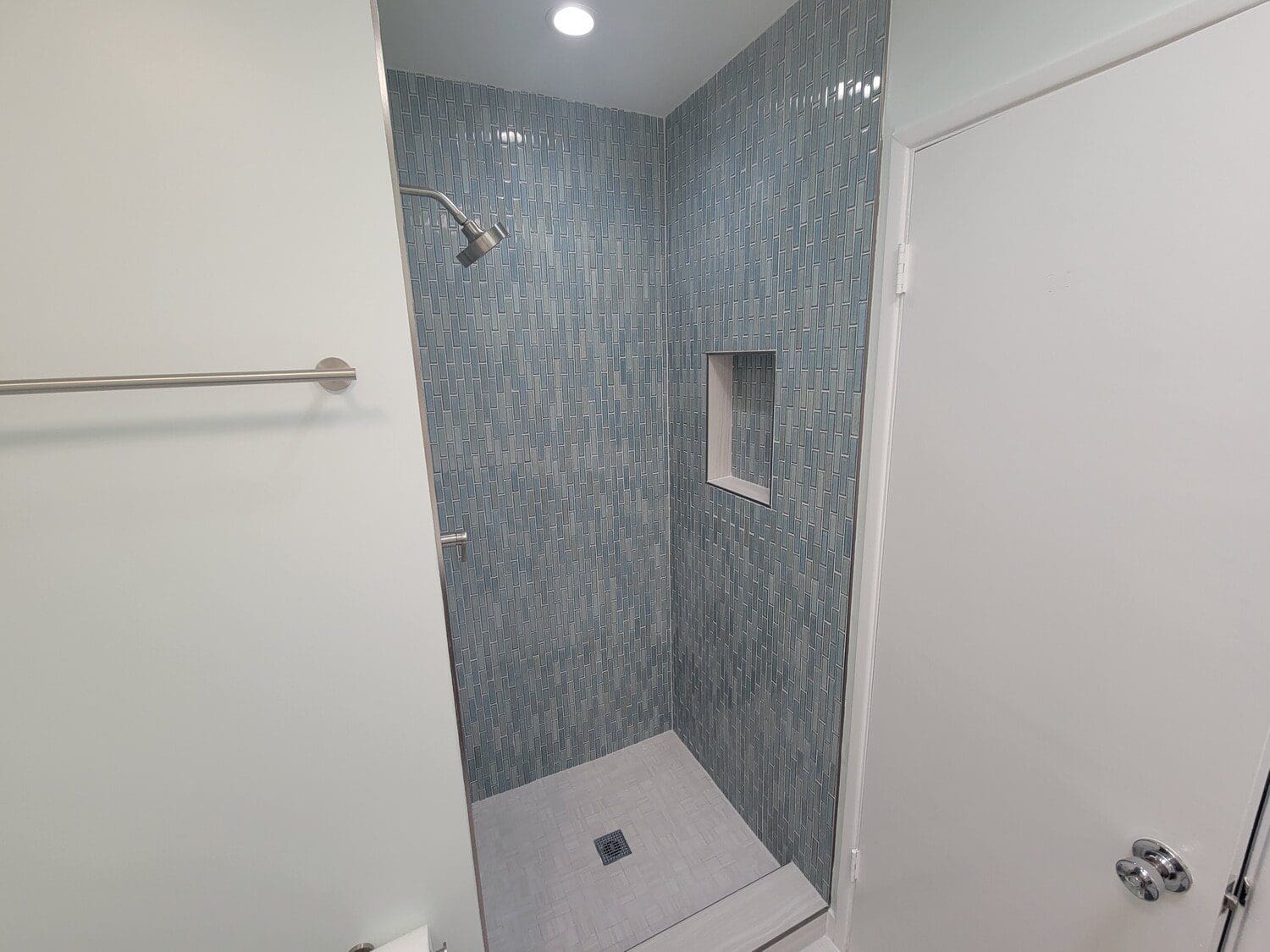 A bathroom with a shower and tiled walls.