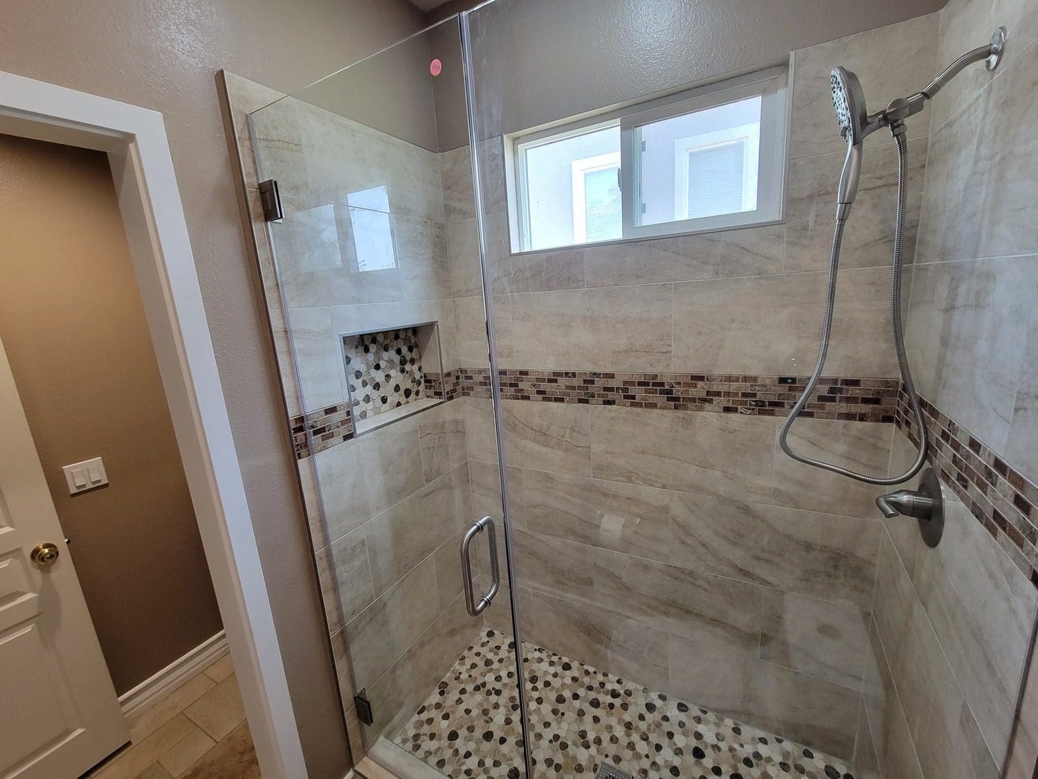 A bathroom with a shower and tiled floor