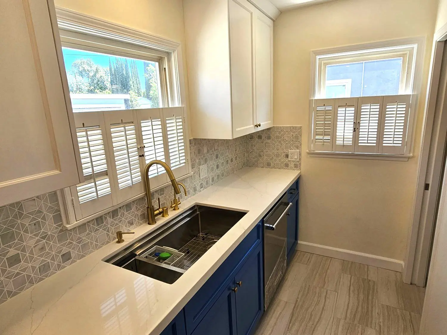 A kitchen with blue cabinets and white counters