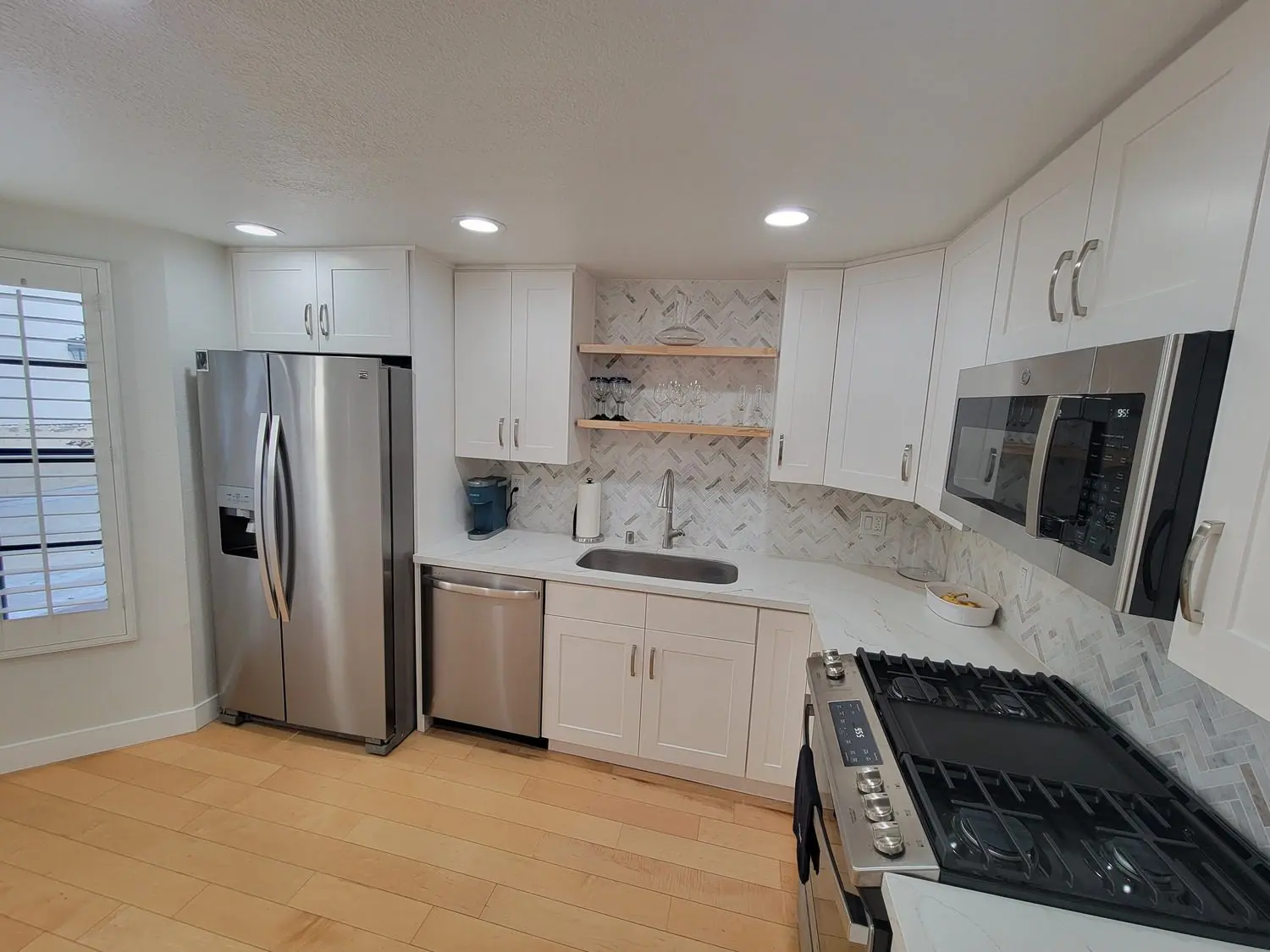 A kitchen with white cabinets and stainless steel appliances.