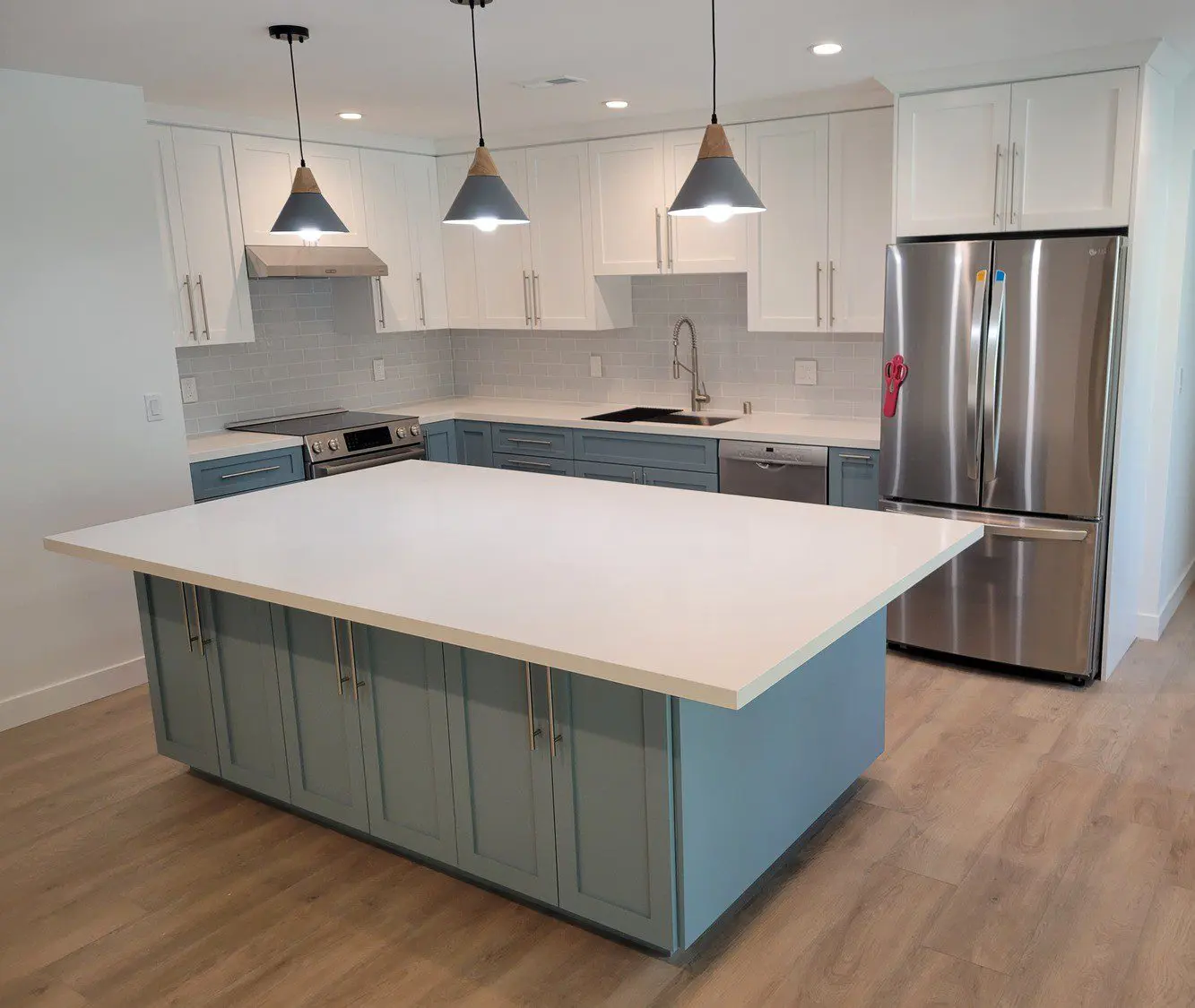 A kitchen with a large island and stainless steel appliances.