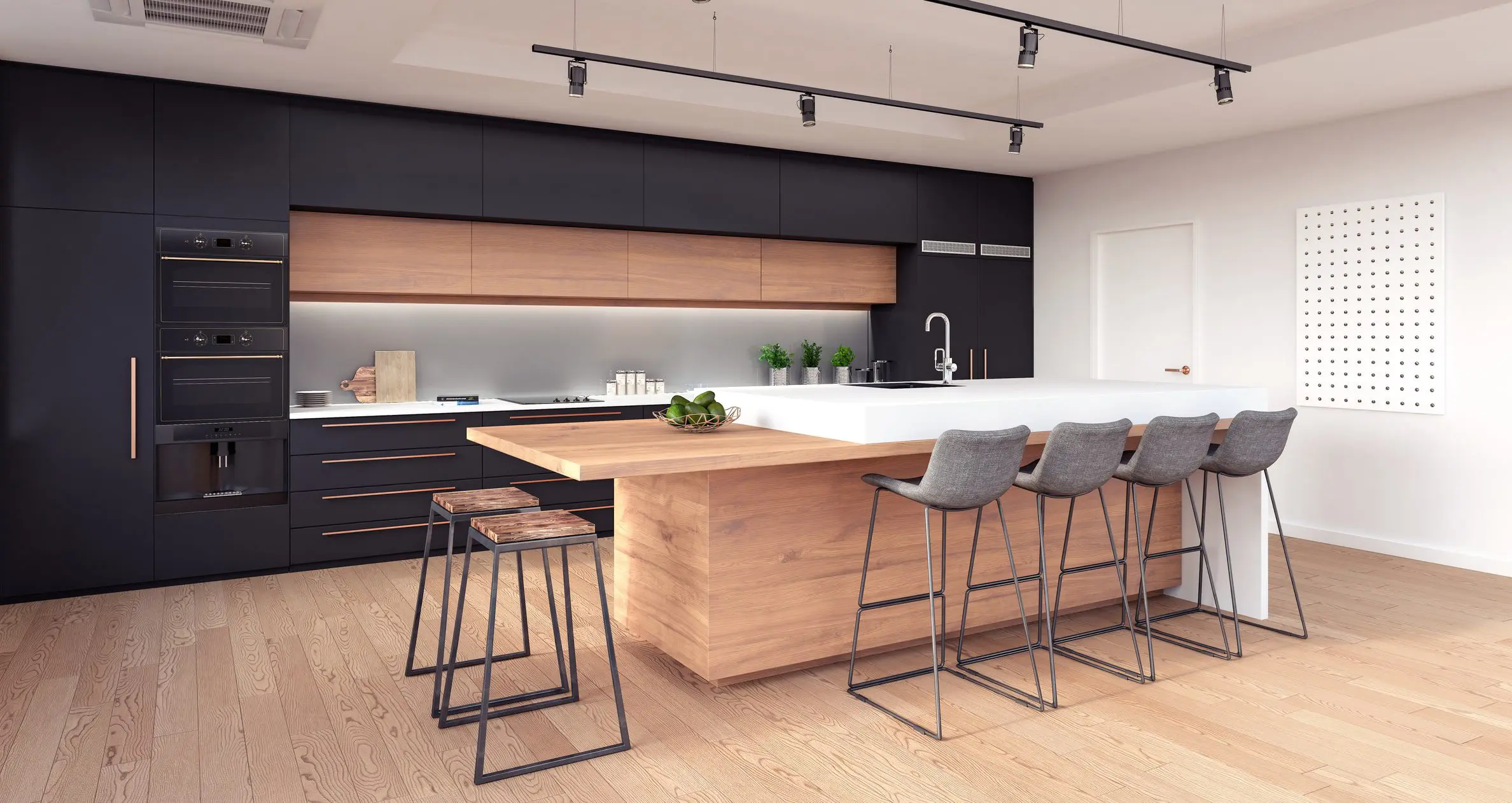 A kitchen with black and white cabinets, wooden floors and bar stools.