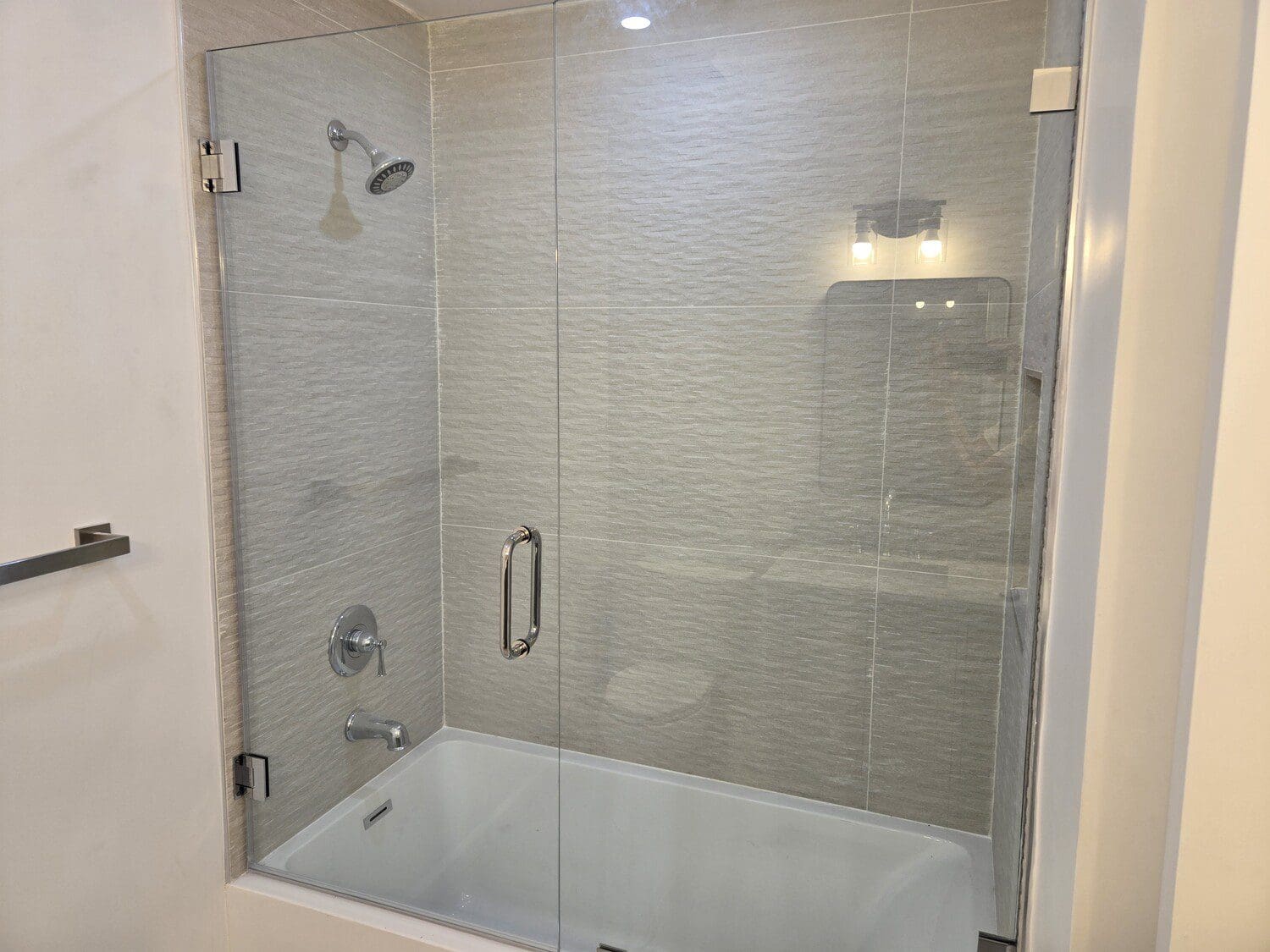 A bath tub and shower combination in a bathroom.