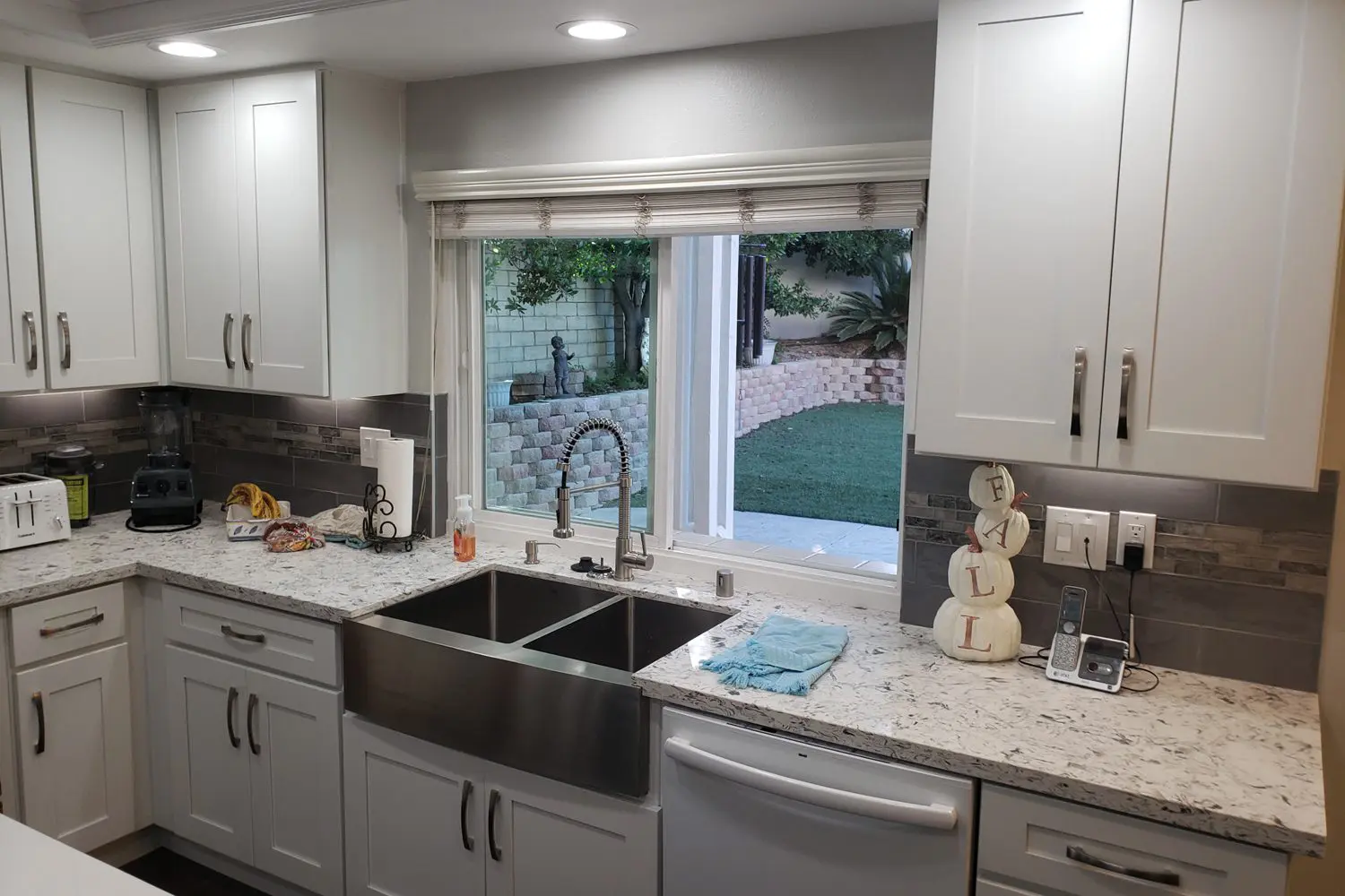 A kitchen with white cabinets and a sink.