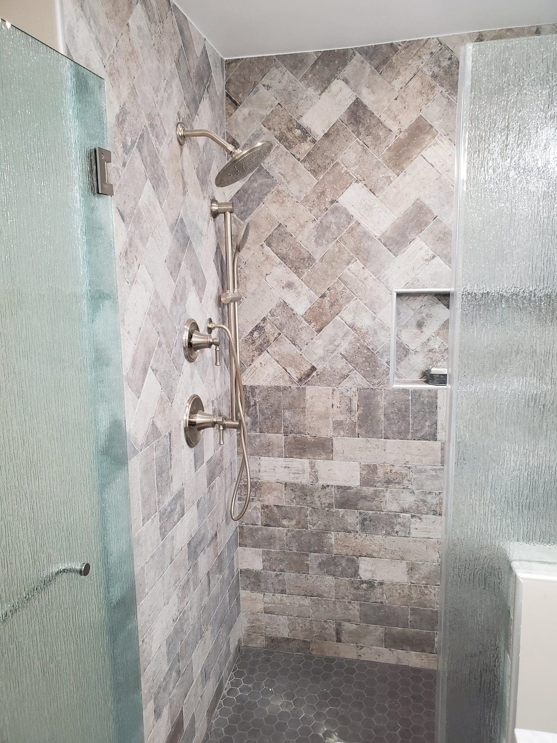 A bathroom with a shower and tiled walls.