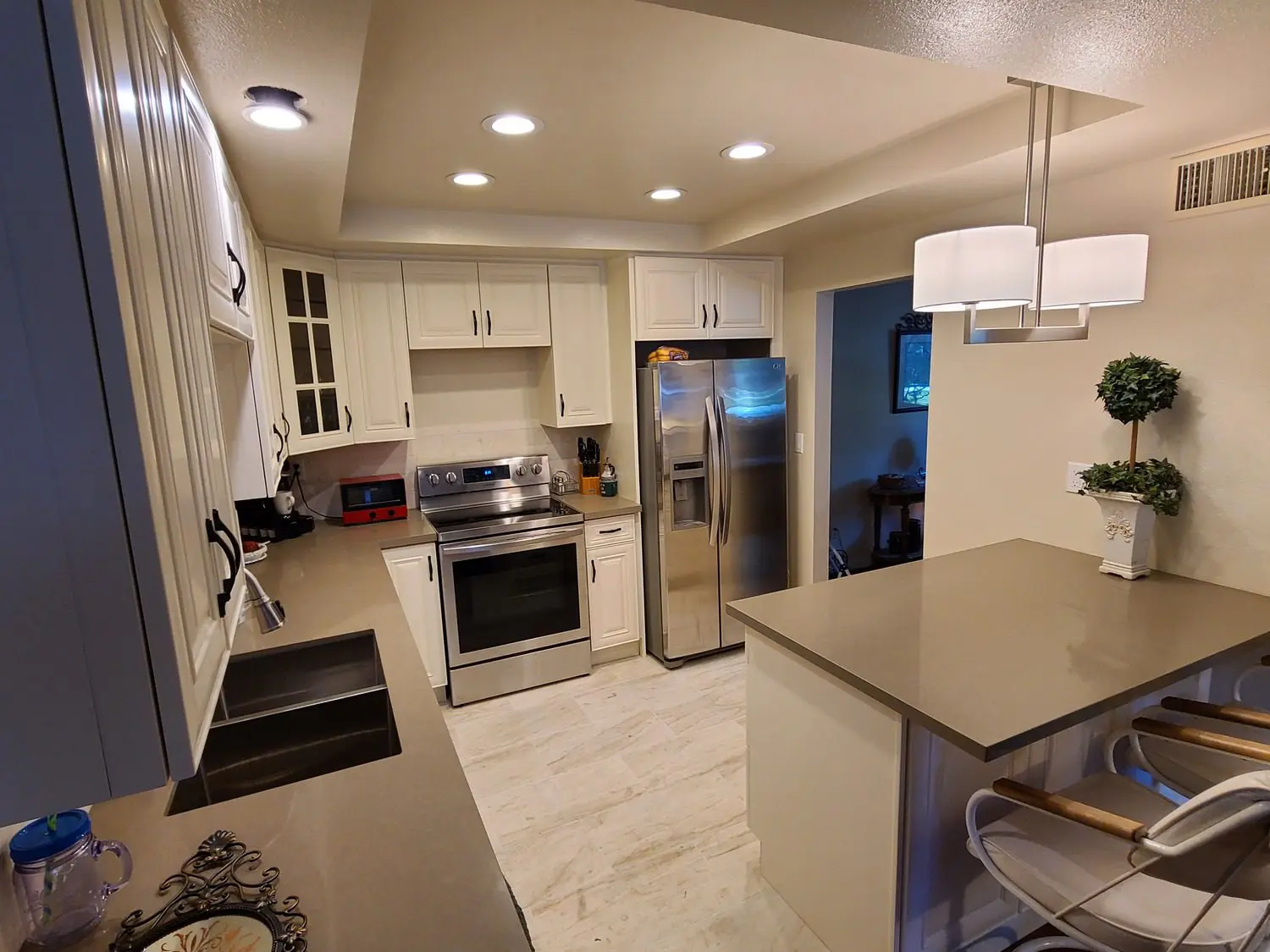 A kitchen with stainless steel appliances and white cabinets.