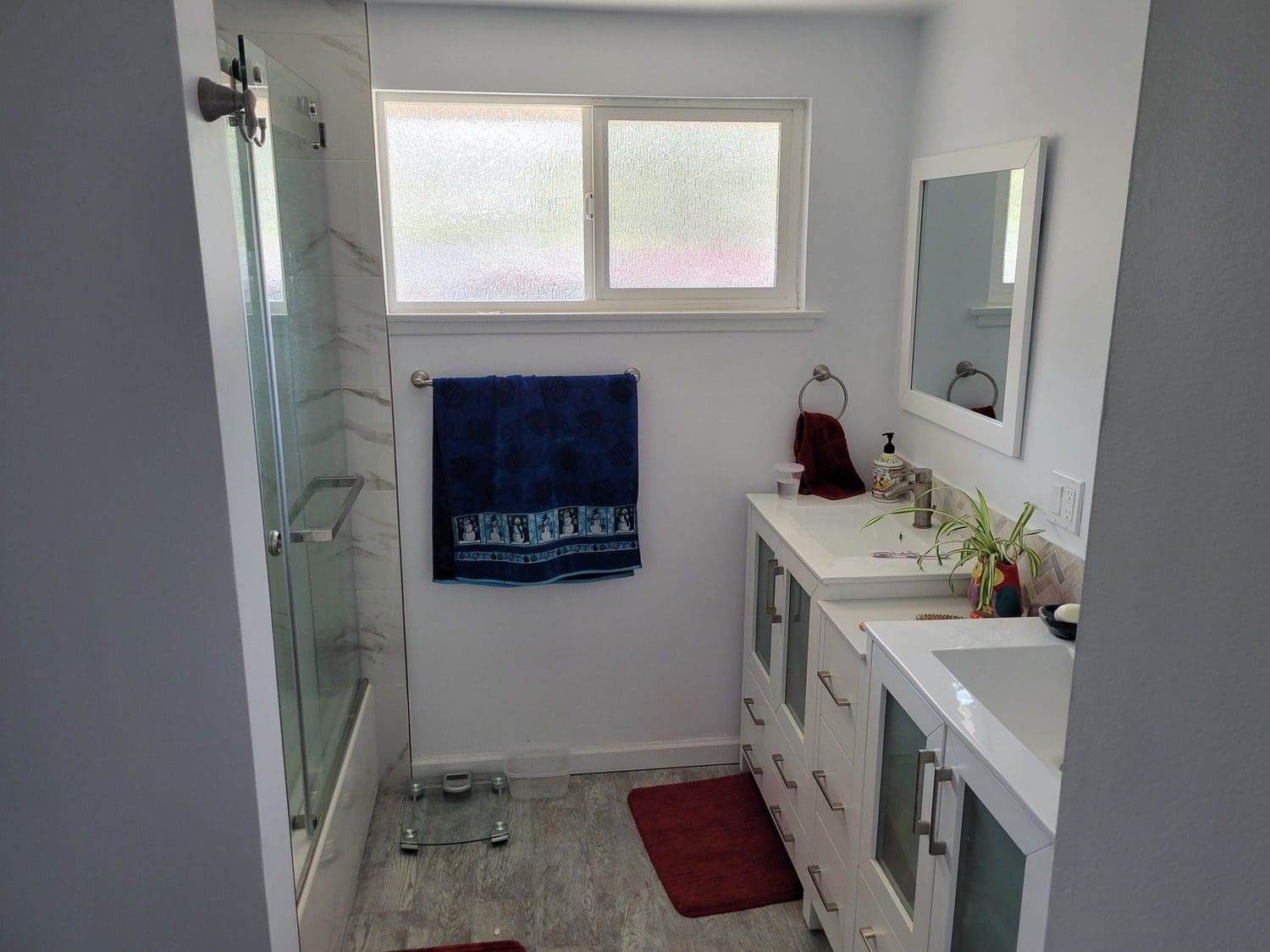 A bathroom with two sinks and a shower.