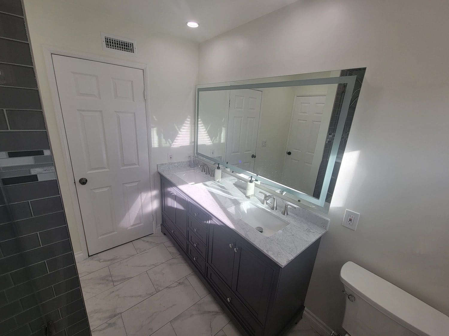 A bathroom with two sinks and a large mirror.