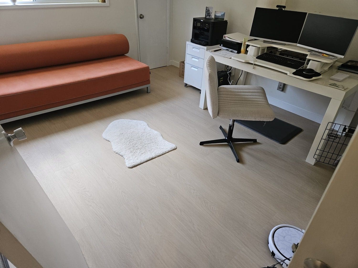 A room with a desk, couch and computer.