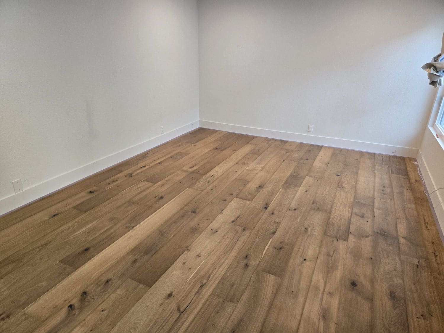 A room with wood floors and white walls.