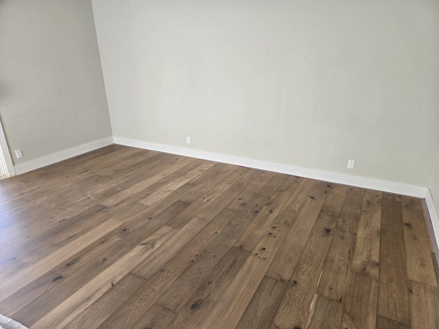 A room with wood floors and white walls.