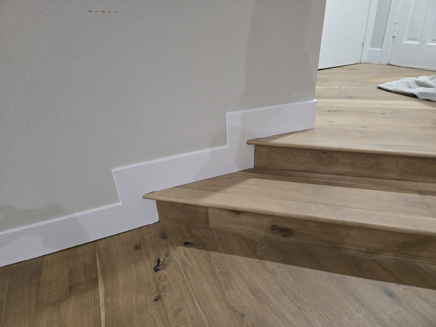 A wooden staircase with white risers and wood treads.