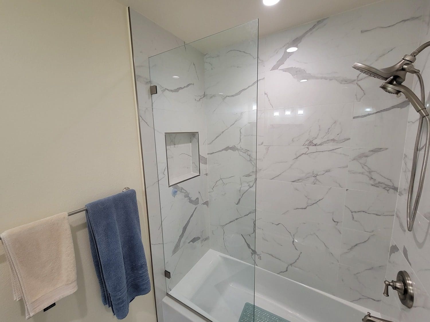 A bathroom with marble walls and white fixtures.