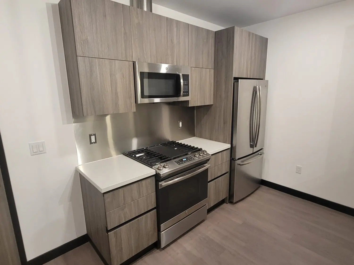 A kitchen with stainless steel appliances and wooden cabinets.