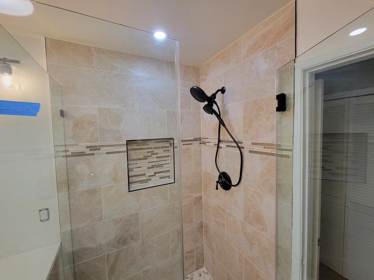 A bathroom with a shower and tiled walls.