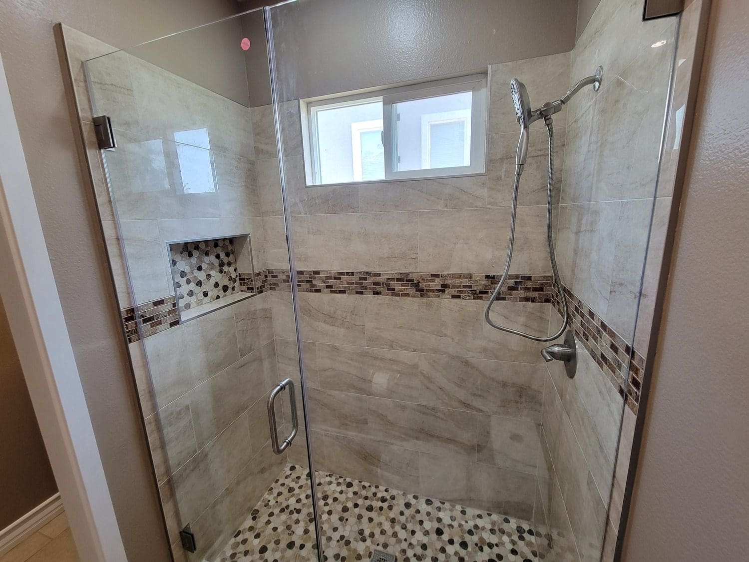 A bathroom with a shower and tiled floor