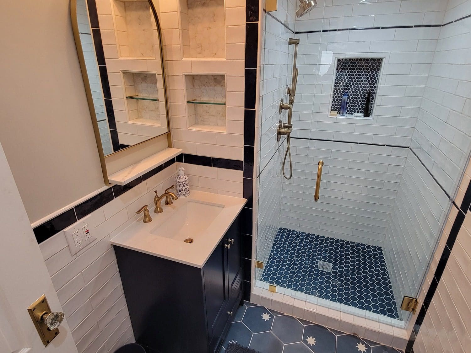 A bathroom with a sink, mirror and shower.