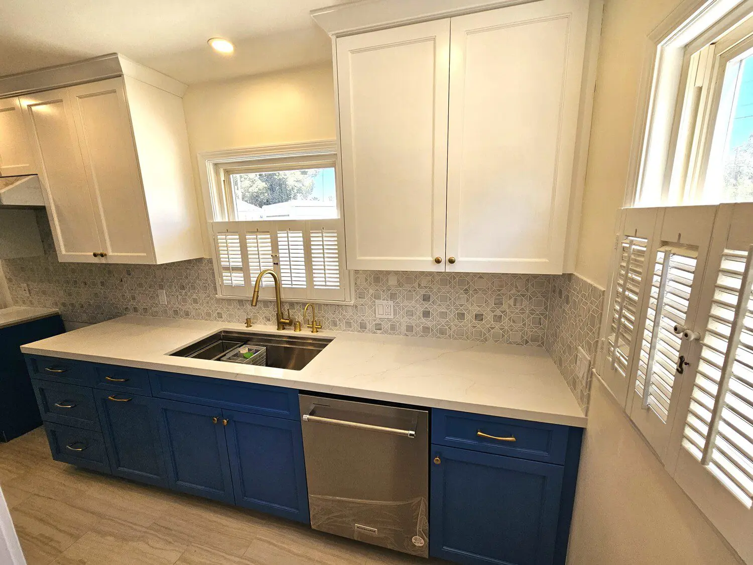 A kitchen with blue cabinets and white counters