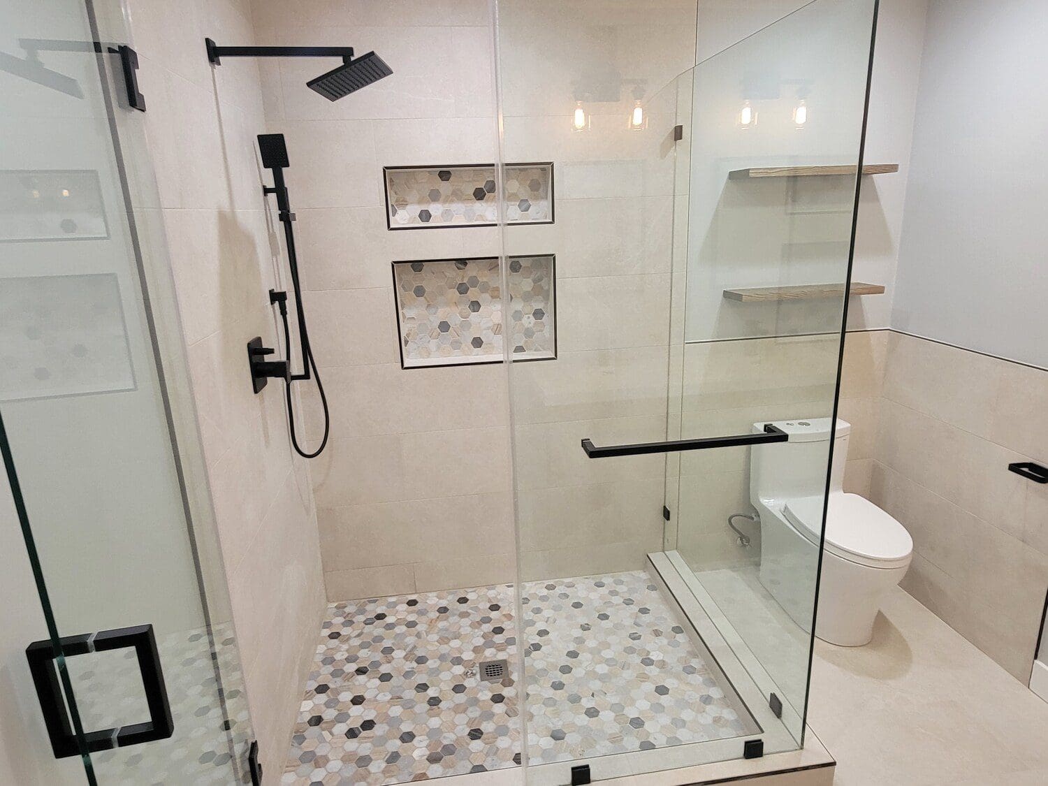 A bathroom with a shower, toilet and tiled floor.