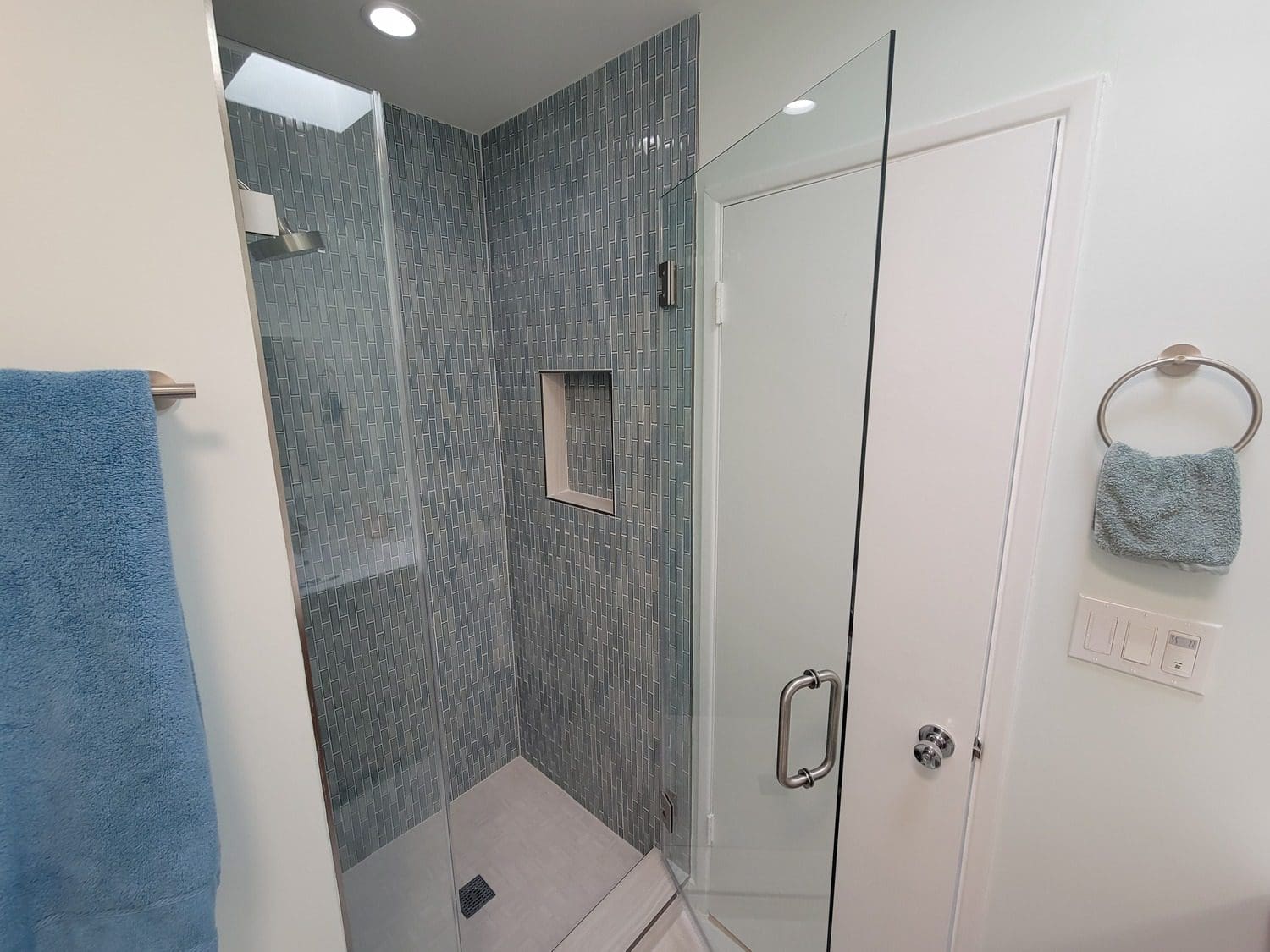 A bathroom with a walk in shower and tiled walls.