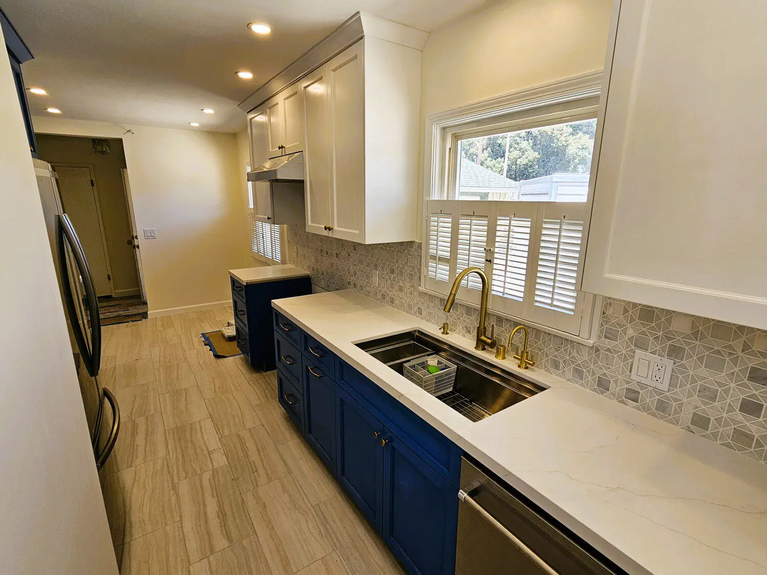 A kitchen with blue cabinets and white counters