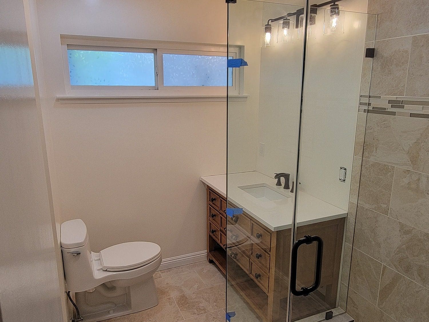 A bathroom with a toilet, sink and shower.