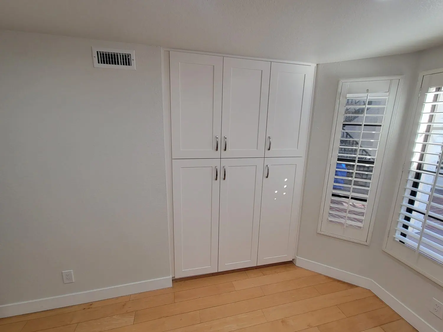 A room with white walls and wooden floors.