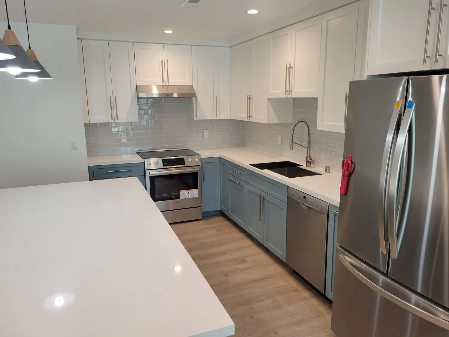 A kitchen with white cabinets and blue doors