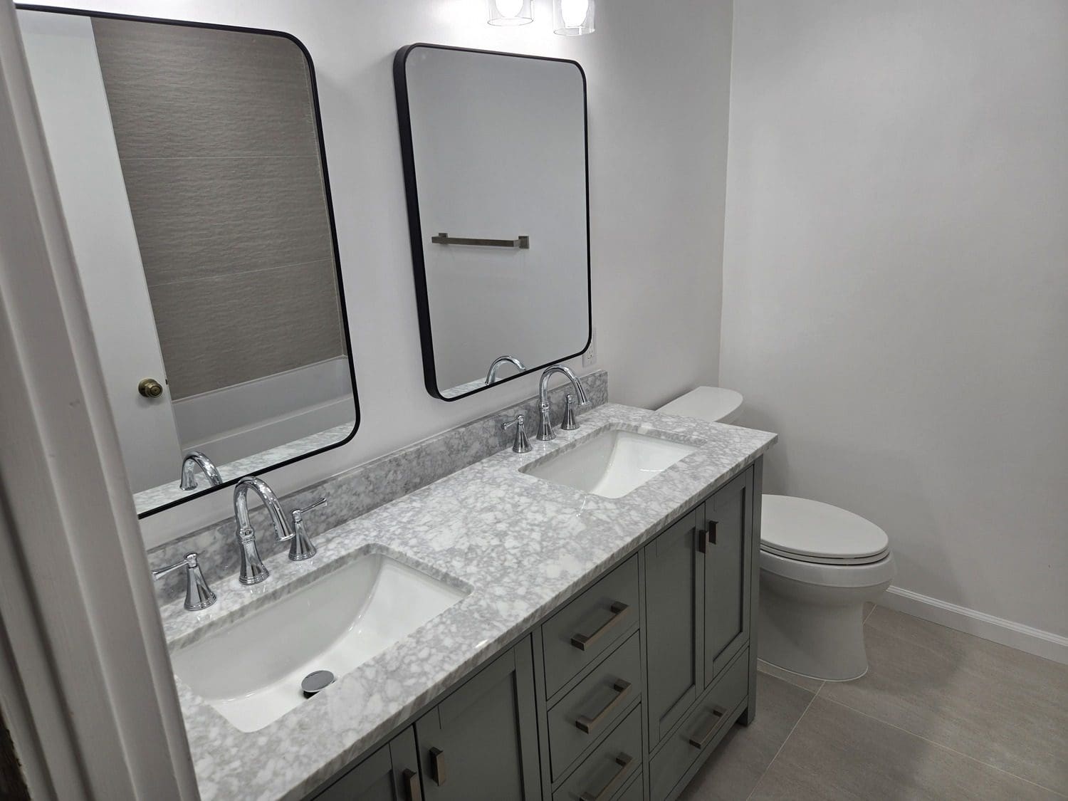 A bathroom with two sinks and a toilet.