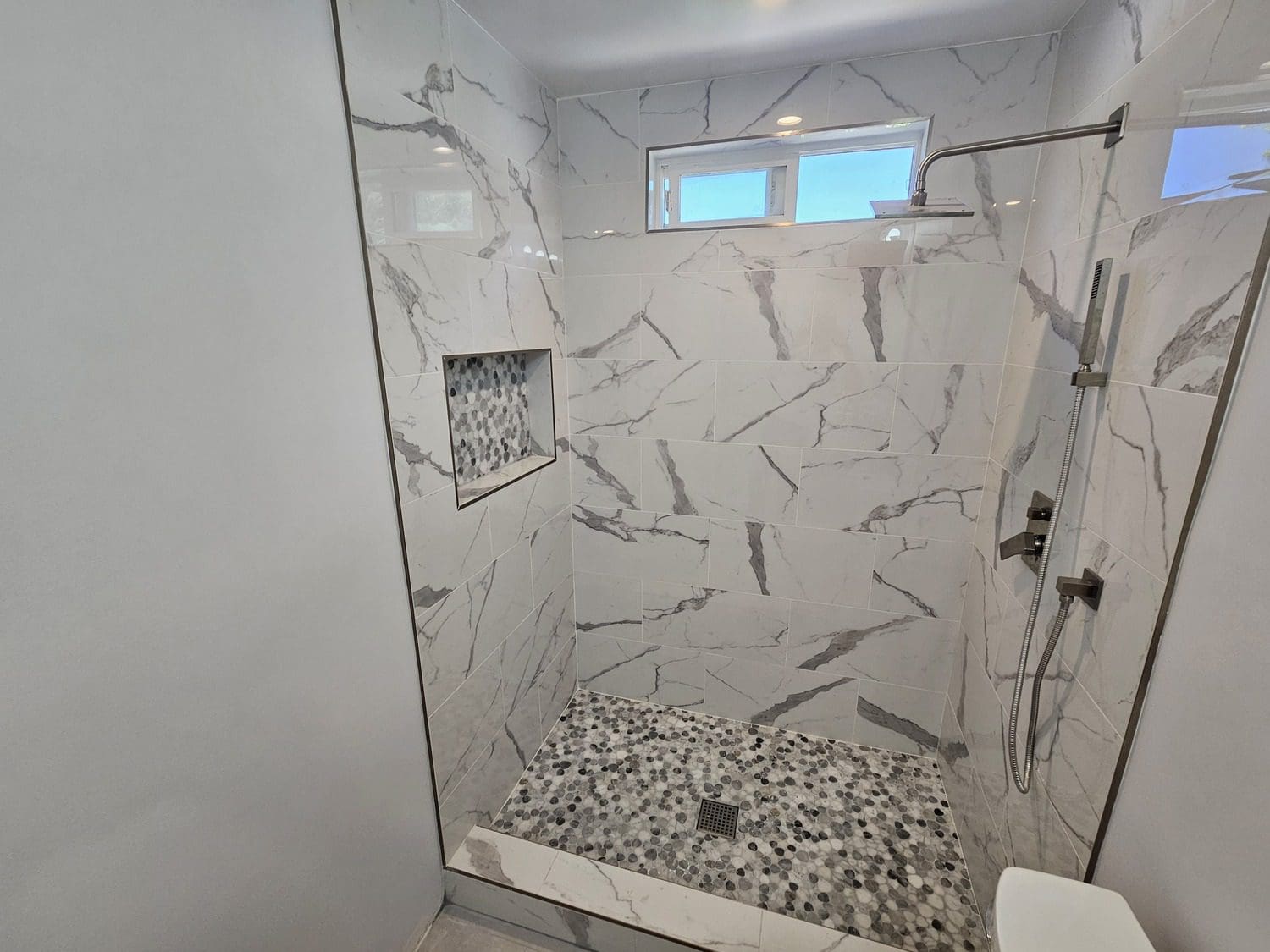 A bathroom with a shower and tiled floor