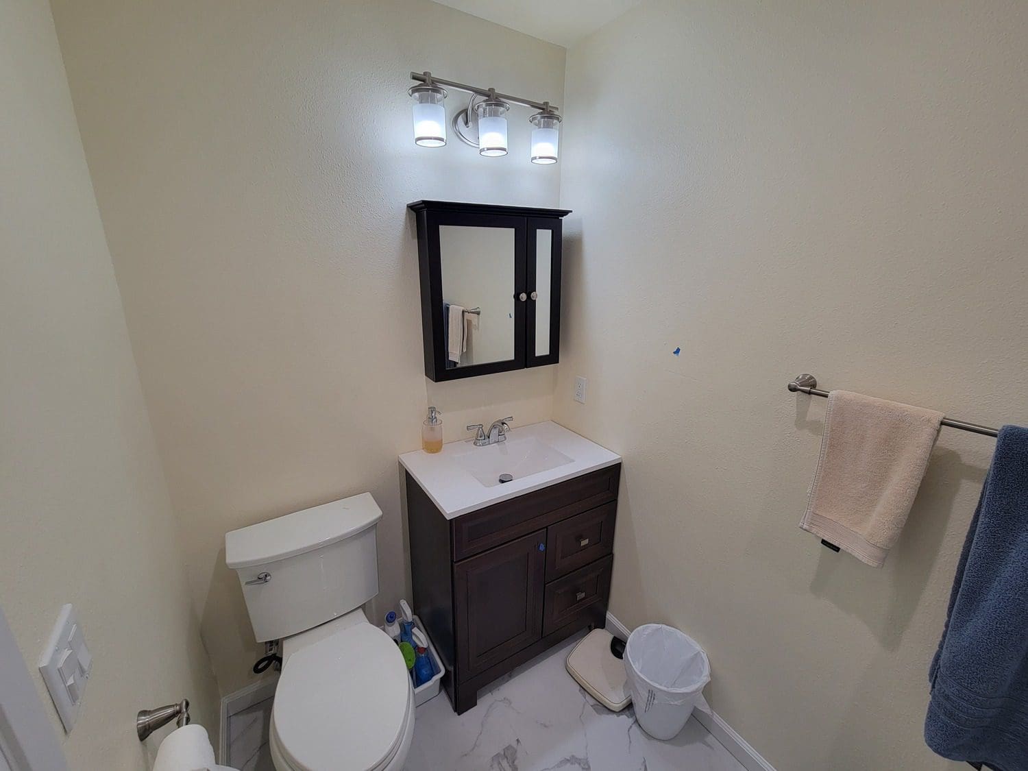 A bathroom with a sink, toilet and mirror.