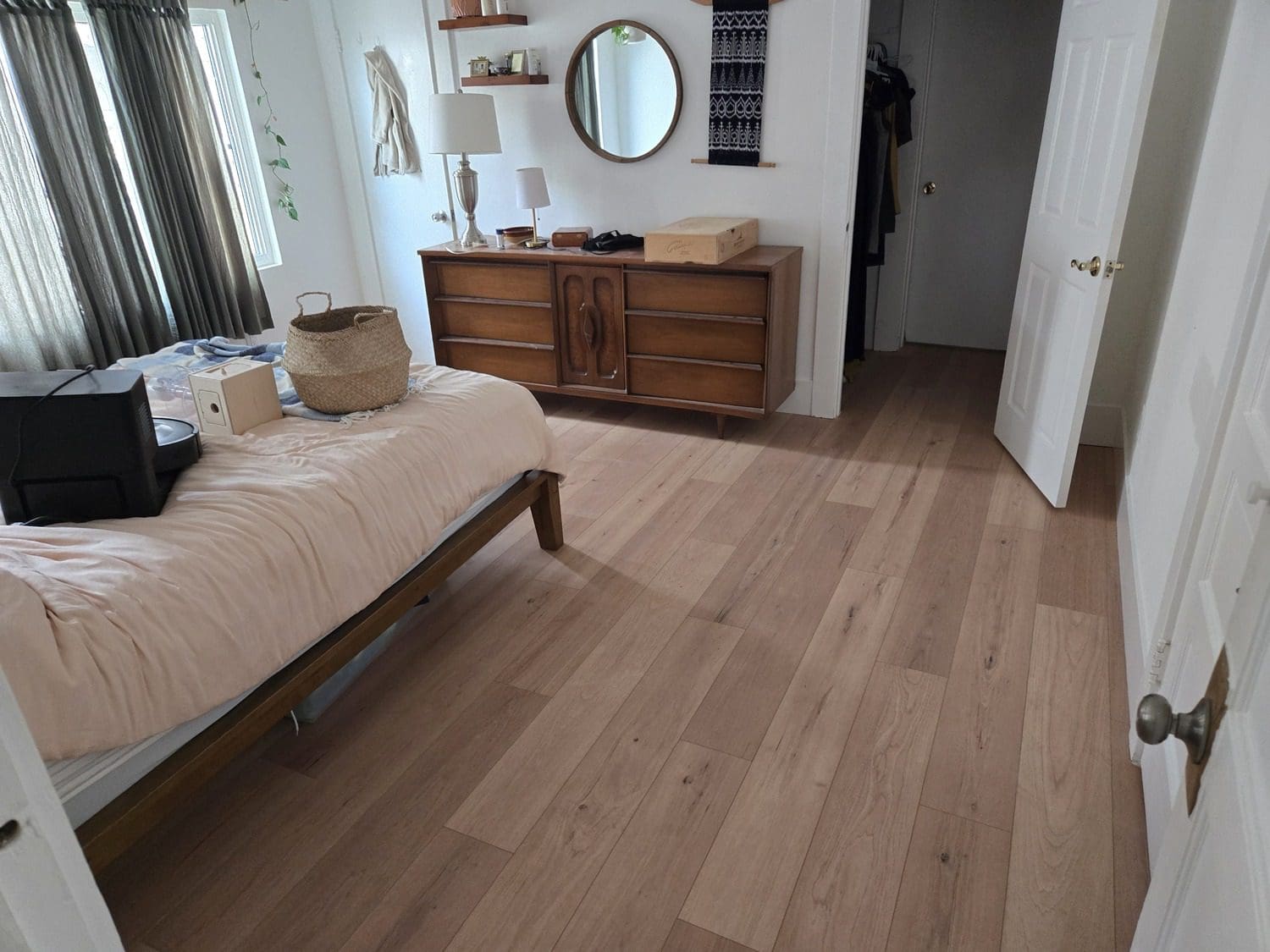 A bedroom with wood floors and a bed