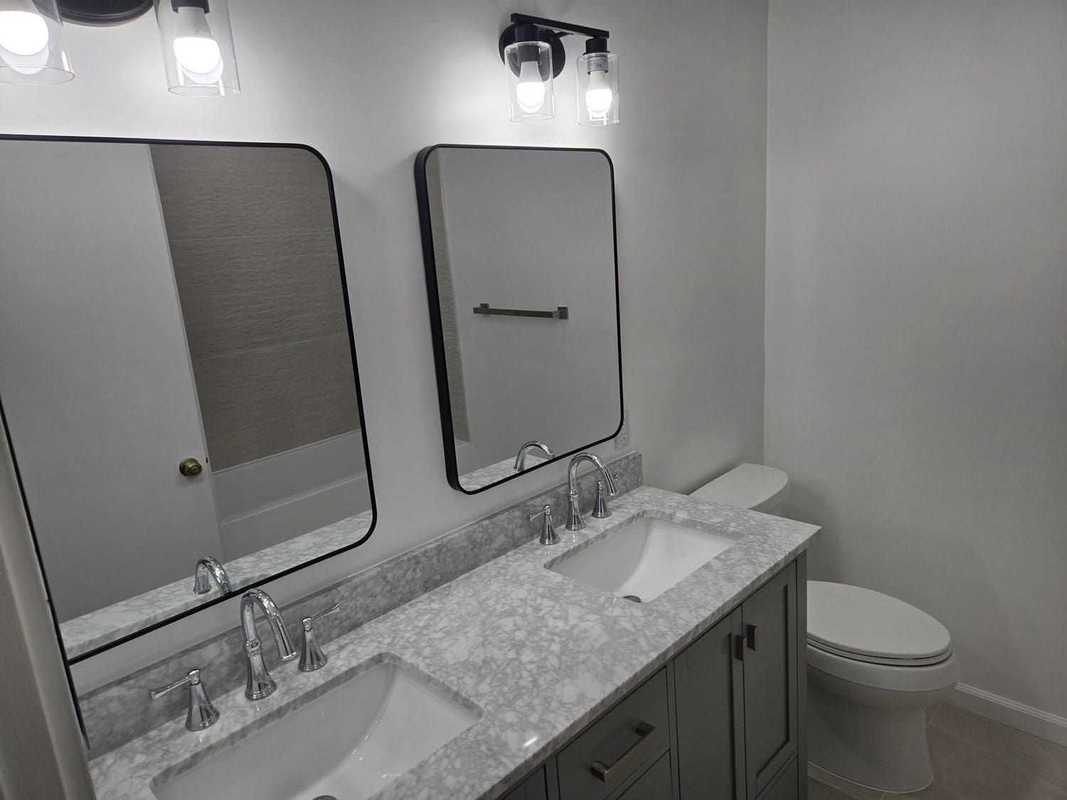 A bathroom with two sinks and mirrors in it