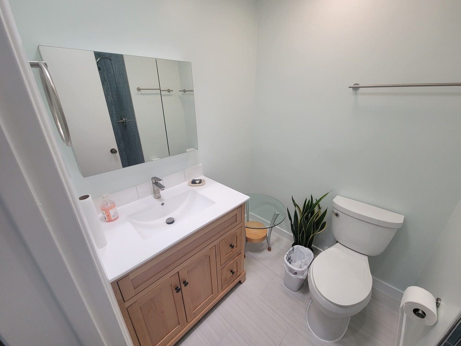 A bathroom with a sink, toilet and mirror.