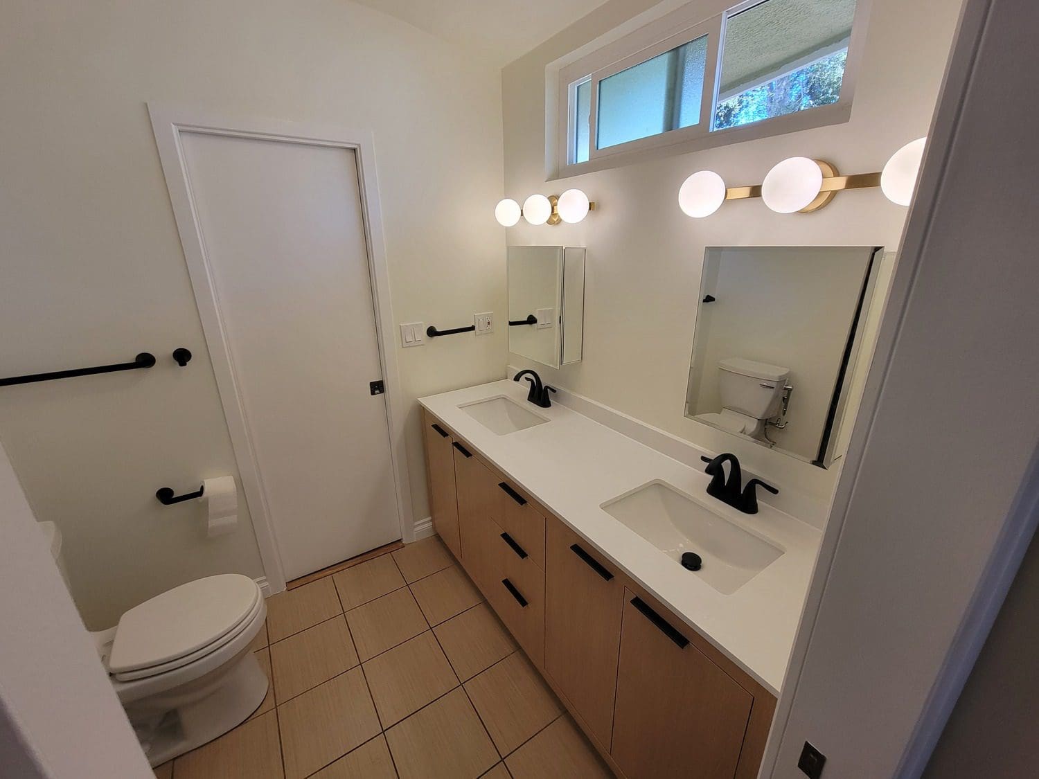 A bathroom with two sinks and a toilet.