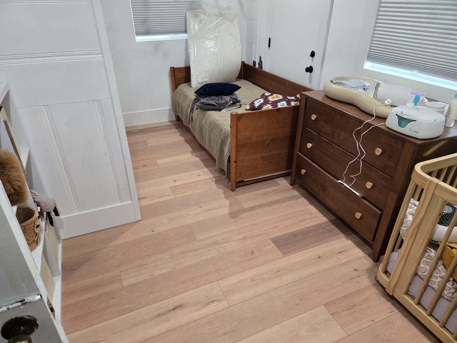 A bedroom with hard wood floors and a bed.