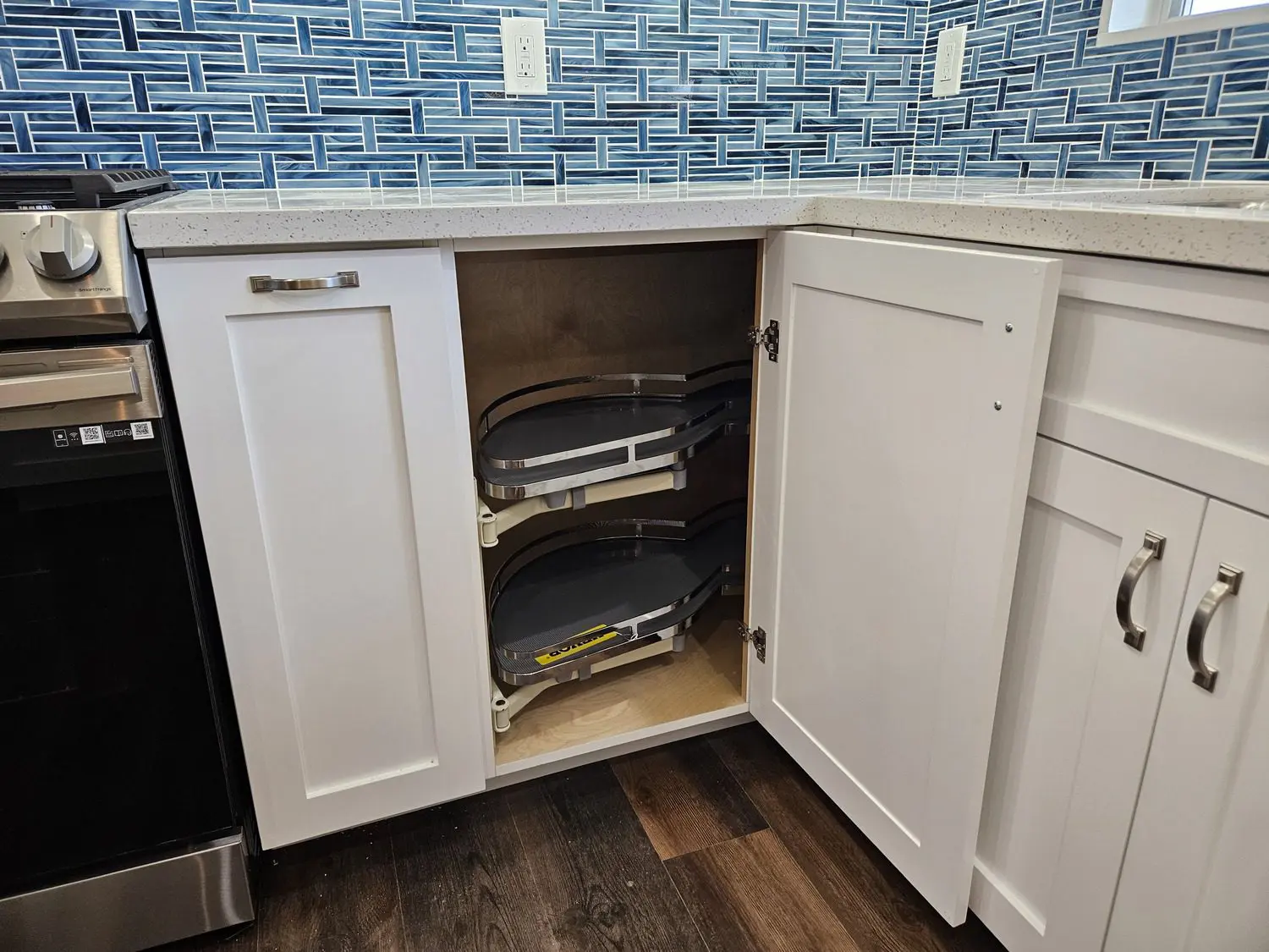 A kitchen with white cabinets and blue tile backsplash.