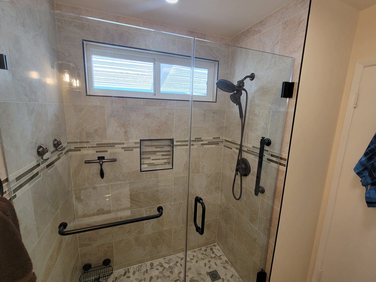 A bathroom with a shower and tiled walls.