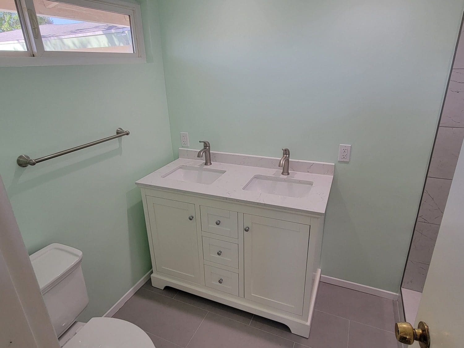 A bathroom with two sinks and a toilet.