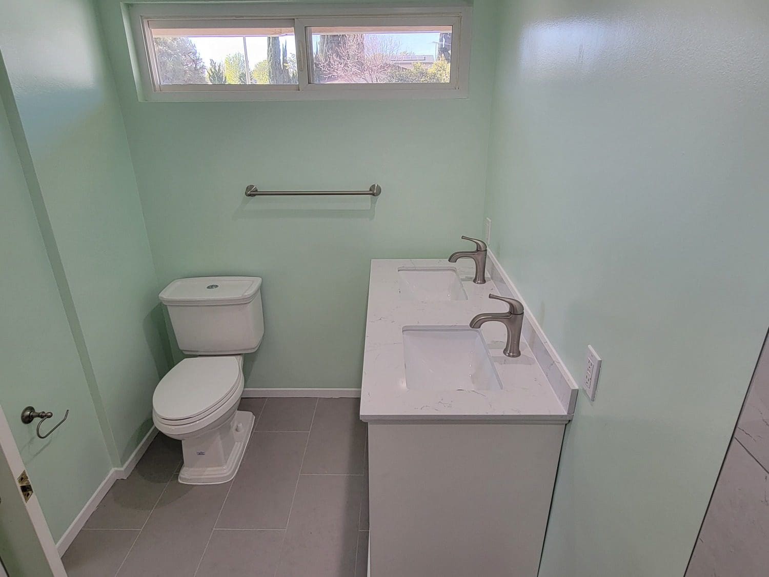 A bathroom with two sinks and a toilet.