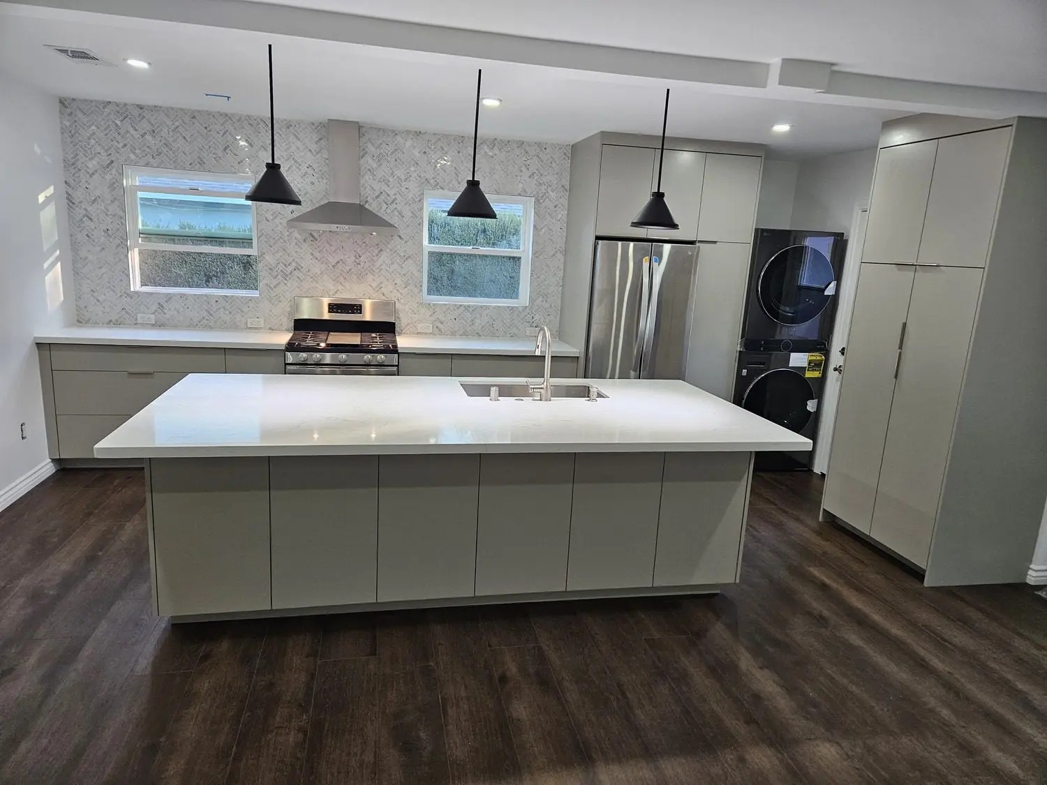 A kitchen with white cabinets and black appliances.