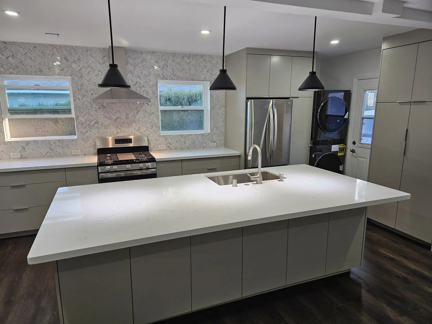 A kitchen with white counters and black lights